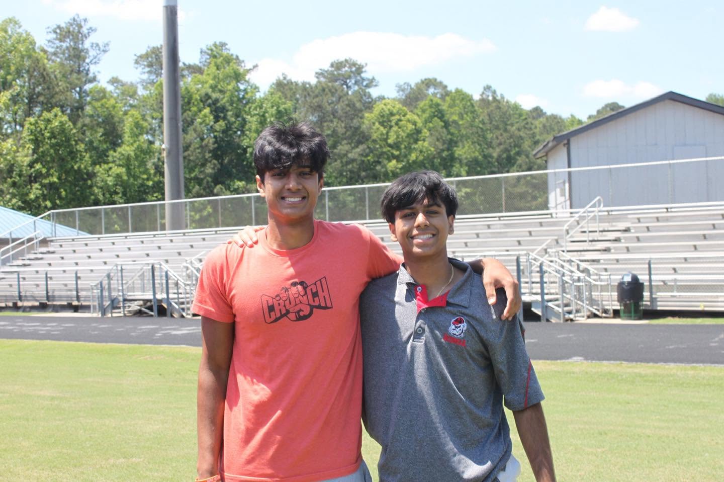 Two young friends smiling on a sports field